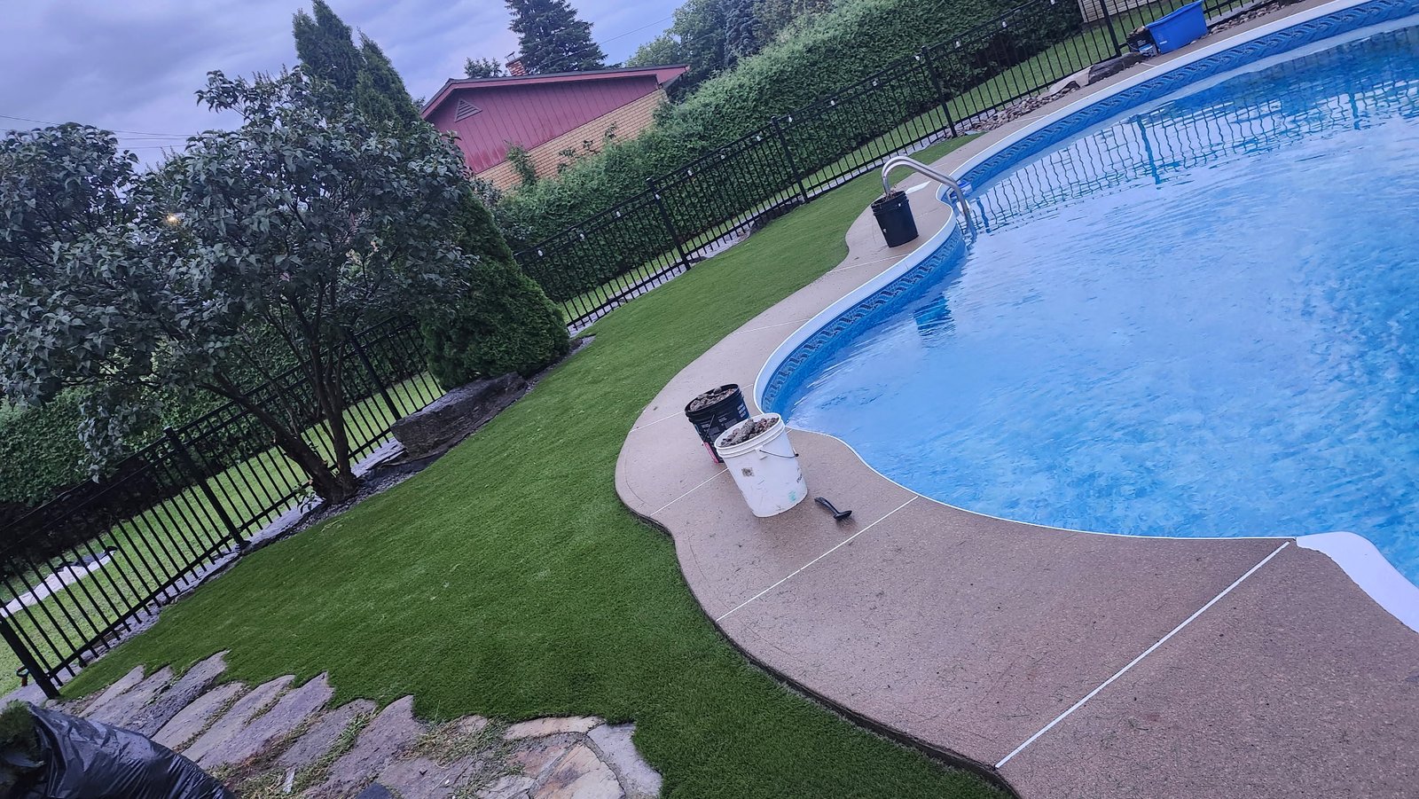 Cour en gazon synthétique bordant une piscine creusée