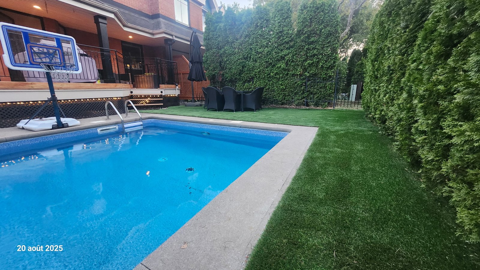 Cour avec gazon synthétique, piscine creusée et mobilier de patio