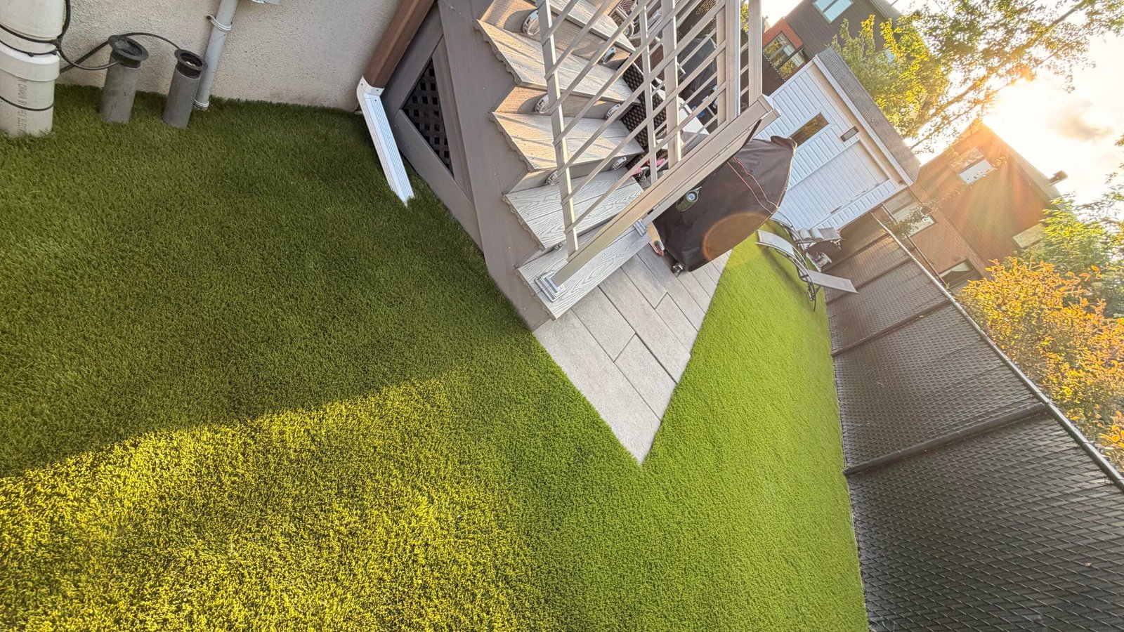 Gazon synthétique installé autour d’une terrasse de bois