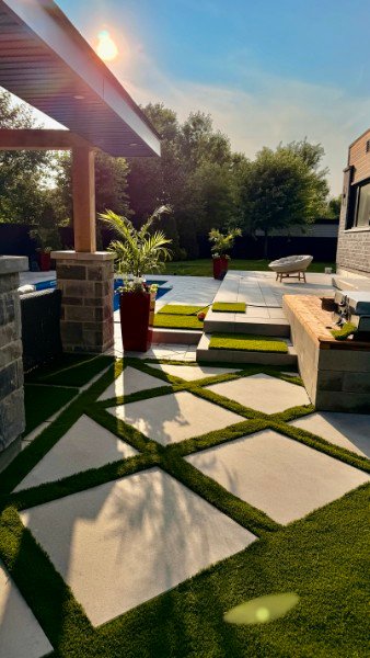 Gazon synthétique intégré entre des dalles de patio
