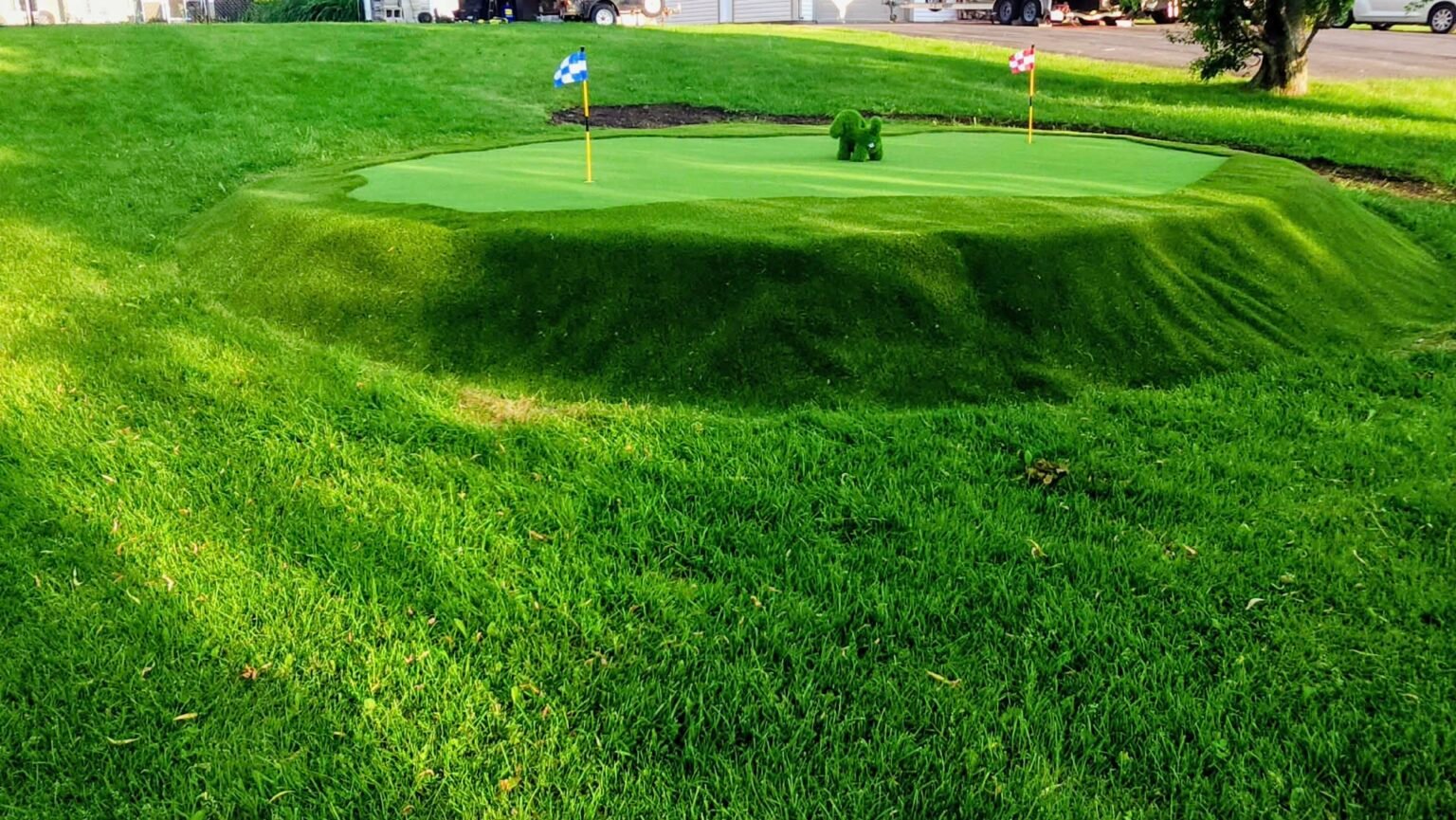Putting green surélevé en gazon synthétique avec deux drapeaux et une frange