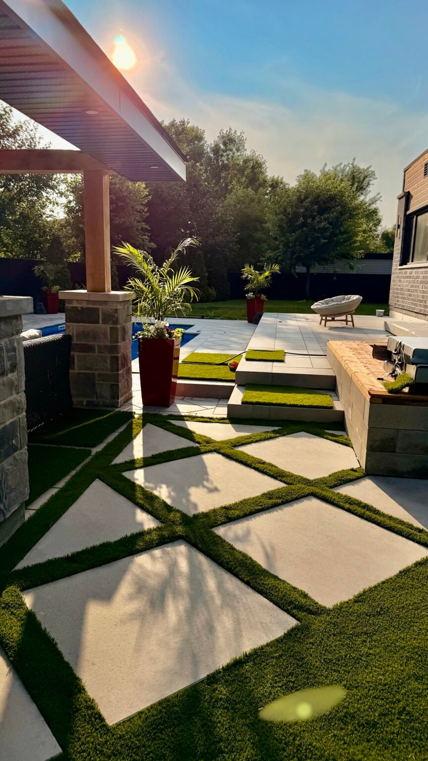 Dalles en diagonale avec joints de gazon synthétique près d'une piscine et d'une pergola